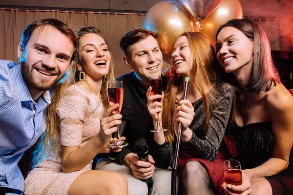 Skupina mladých lidí houpající se v karaoke baru — Stock fotografie