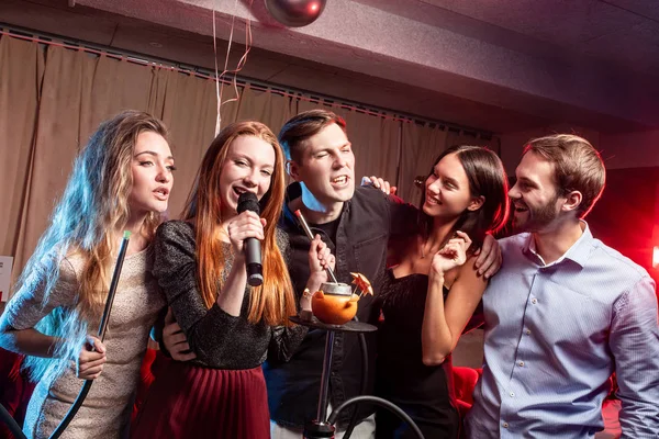 Koncepce zábavy a večírku. mladí lidé v karaoke — Stock fotografie
