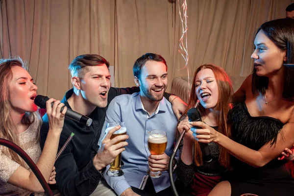 Damas y chicos bebiendo, cantando y fumando narguile — Foto de Stock