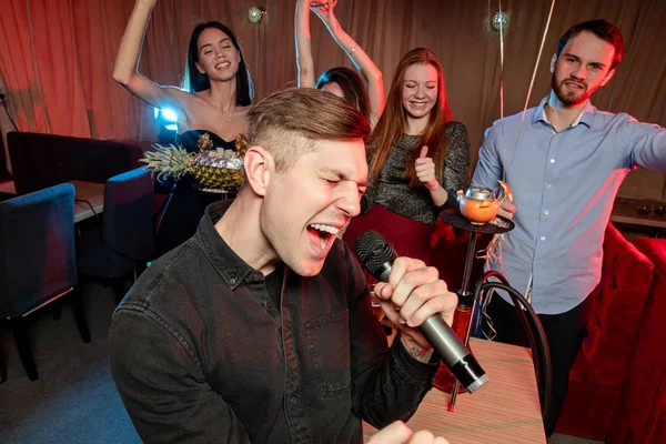 Trendy young singers in karaoke bar — Stock Photo, Image