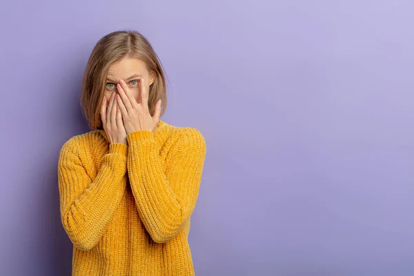 Portrait of scared young woman isolated over purple background — Stock Photo, Image