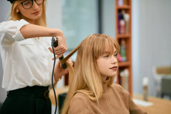 Cabeleireiro profissional alisar o cabelo com ferro de cabelo — Fotografia de Stock