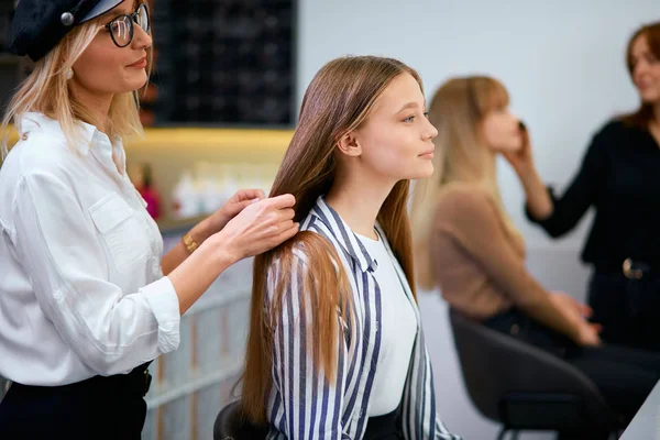 Parrucchiere attento tenendo i capelli dei clienti in mano — Foto Stock