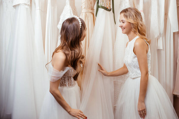 two young women choosing dress for wedding