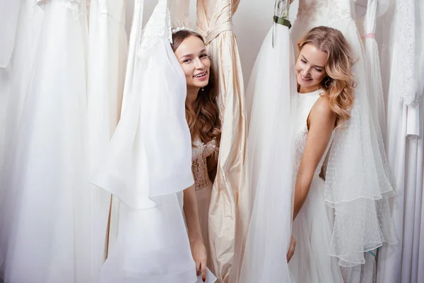 Deux copines caucasiennes parmi les robes de mariée — Photo