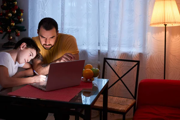 Jonge vader helper en studeren kind jongen thuis — Stockfoto