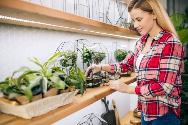 Mutlu kadın çiçekçi çiçeklerle çalışmaktan zevk alıyor.