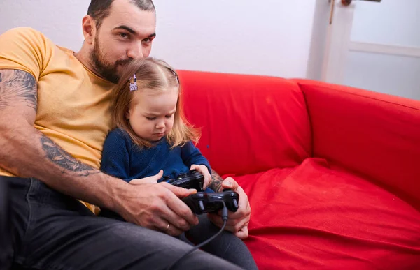 Lindo niño niña sentarse con padre mientras él está jugando video juegos — Foto de Stock