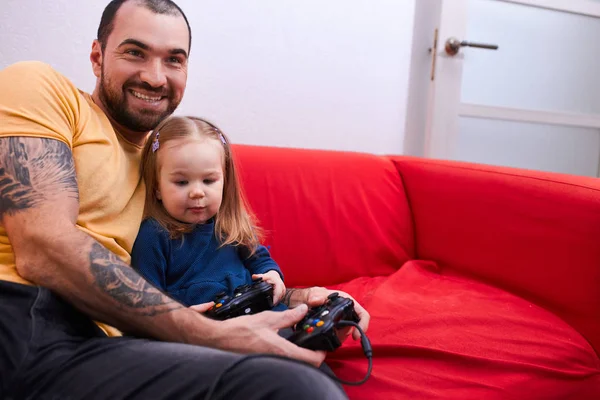 smiling caucasian daughter and father play video games