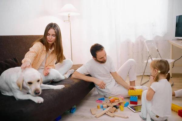 Família positiva amigável ter animal de estimação em casa — Fotografia de Stock