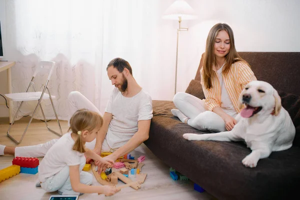 Προσεκτικός άντρας με παιδιά και ελκυστική γυναίκα με σκύλο στο σπίτι — Φωτογραφία Αρχείου
