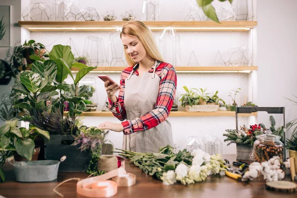 Tiempo libre de la joven florista femenina en el trabajo — Foto de Stock