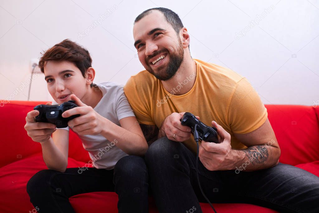 friendly uncle or brother and kid boy play video game