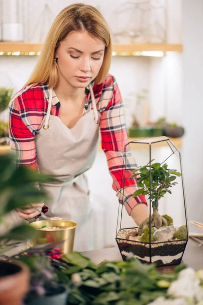 Çiçekçide çiçeklerle ilgilenen bayan çiçekçi.