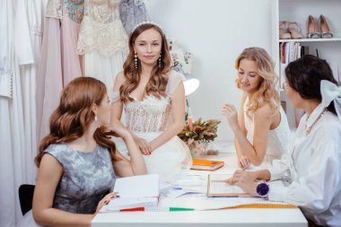 cheerful group of models with professional designer of dresses