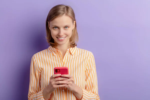 Красивая улыбающаяся белая женщина с мобильным телефоном в руках — стоковое фото