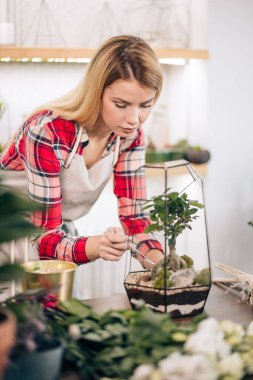 Çiçekçide dikkatli bir bayan.