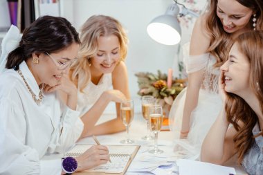 cheerful group of models with professional designer of dresses