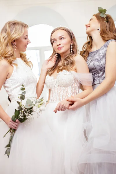 Drei kaukasische Bräute mit schönen Haaren und Make-up posieren im Salon — Stockfoto