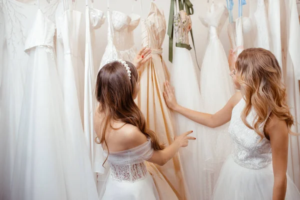 Duas jovens mulheres escolhendo vestido para o casamento — Fotografia de Stock