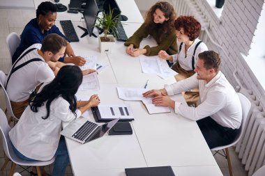 Yoğun iş, iş adamları çalışırken masada oturuyor.