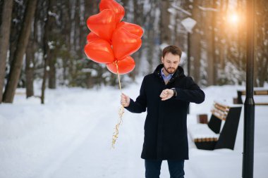 Yakışıklı, beyaz, romantik bir adam bir kadınla buluşmayı bekliyor.