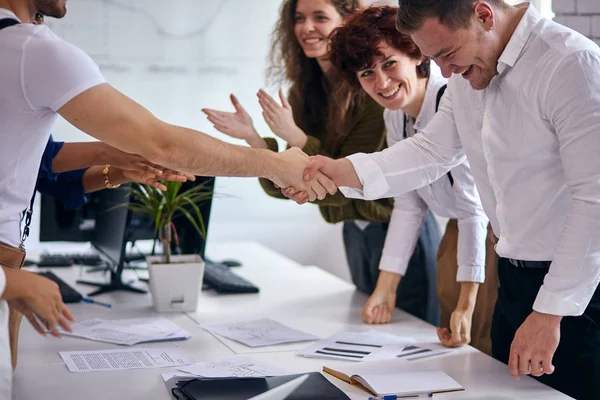 Dos personas de negocios estrechando la mano en la oficina cerca de la mesa — Foto de Stock