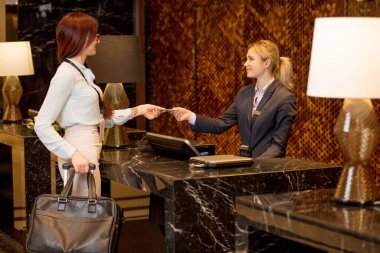 Kolay hareket, kadın otel resepsiyonunda kredi kartıyla ödeme.