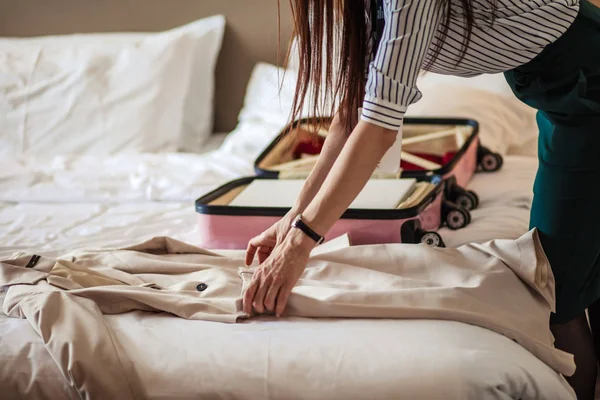 Woman in elegant clothes packing things into travel bag, departing from hotel — Stock Photo, Image