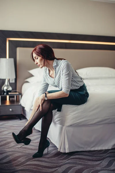 Senhora de negócios cansada depois de uma longa viagem descansando na cama no quarto de hotel . — Fotografia de Stock