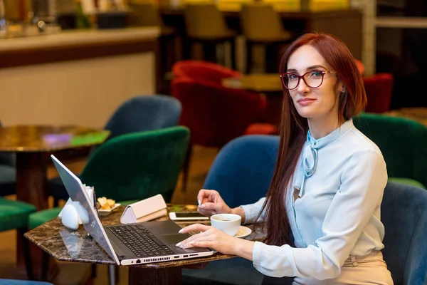 Mujer de negocios que trabaja en el vestíbulo del hotel con ordenador portátil y café — Foto de Stock