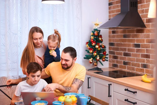 Mladí rodiče s dětmi sedí spolu v kuchyni — Stock fotografie