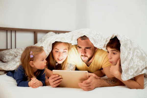 Surprised parents and kids looking at screen of tablet — Stock Photo, Image