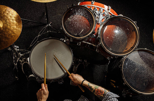 профессиональный барабанщик играет на барабанах в студии
