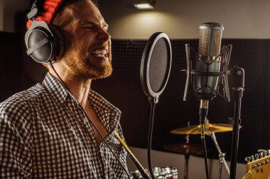 Profesyonel şarkıcı kayıt stüdyosunda şarkı söylüyor.