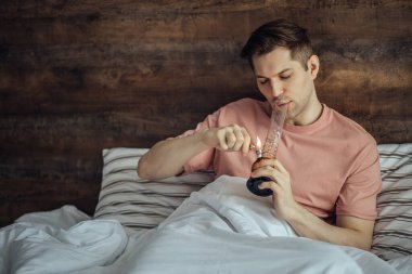 Uyuşturucu kullanıcısı şişeyi esrar ile ısıtıyor.