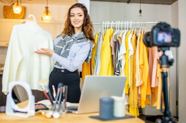 Genç gülümseyen güzellik blogcusu yeni bluzunu kameraya sunar.