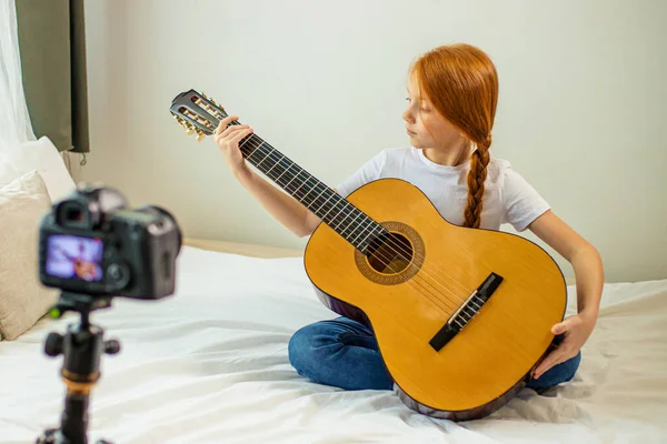 Dulce niña blogger estudiar acordes en la guitarra acústica —  Fotos de Stock