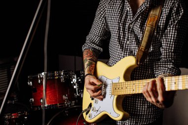 Kırpılmış adam elektro gitar kullanarak müzik yapıyor.