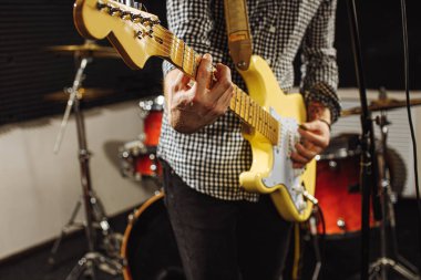 Kırpılmış adam elektro gitar kullanarak müzik yapıyor.