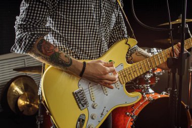Elektro gitar çalan kırpılmış adam.