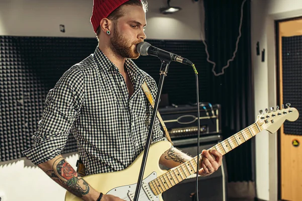 professional guitarist singing on microphone