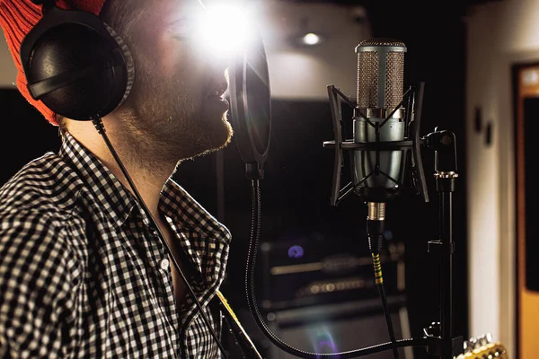 Sidovy på kaukasisk ung man sjunger i studio — Stockfoto