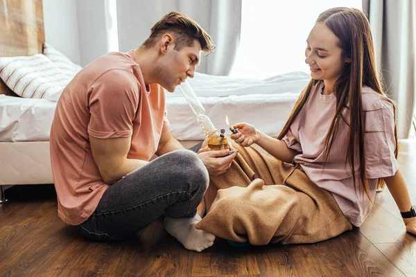 Couple lighting a bong with cannabis — Stock Photo, Image