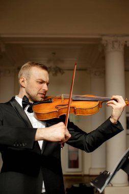 Genç beyaz adam keman çalıyor.