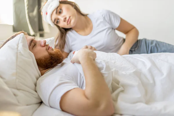 Schattig blank vrouw kijken naar slapen man, wacht als hij wakker wordt — Stockfoto