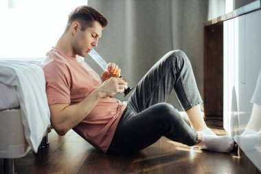 Adam evde esrar tüttürüyor.