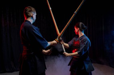 İki Kendo savaşçısı karşı karşıya ve Shinai karanlık uzayda izole edilmiş.
