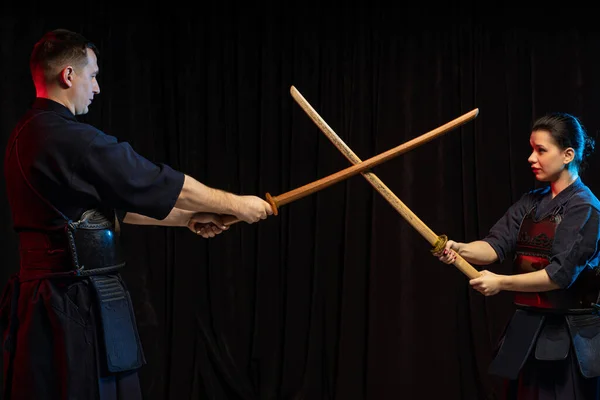 Dois kendo lutadores opostos um ao outro com shinai isolado sobre o espaço escuro — Fotografia de Stock