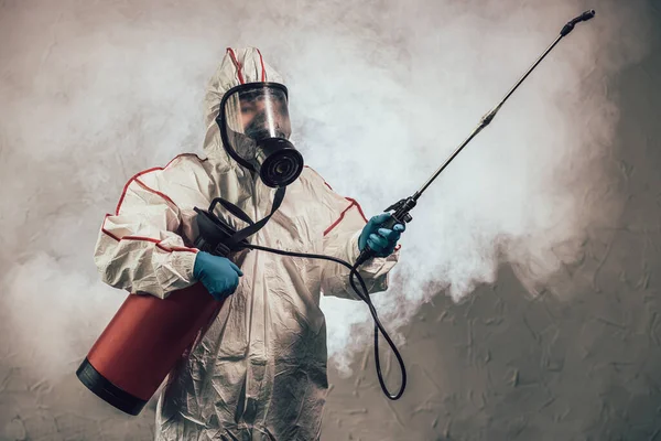 Disinfector in protective suit conducts disinfection — Stock Photo, Image